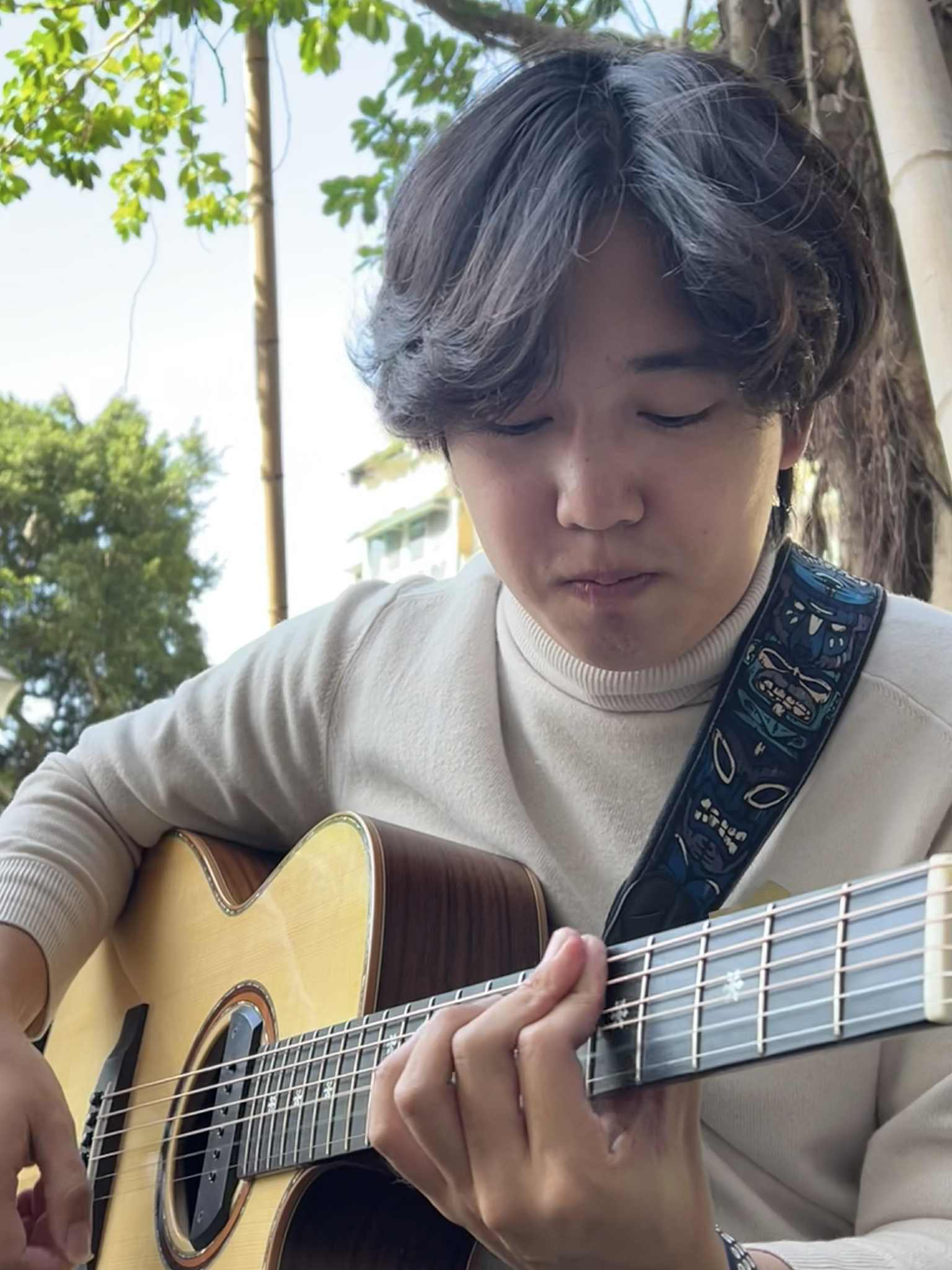 Kuan-Hsun Tu playing an acoustic guitar